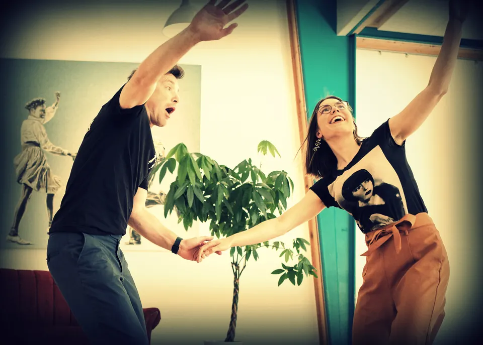 Ein Paar reißt im Studio die Arme hoch, beide staunen und lachen