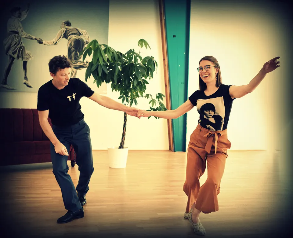 Swing-out en el estudio: una pareja con los brazos extendidos, ella ríe