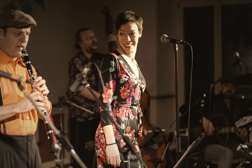 Live-Band auf der Bühne: Klarinettist im orangen Hemd und Sängerin im Blumenkleid