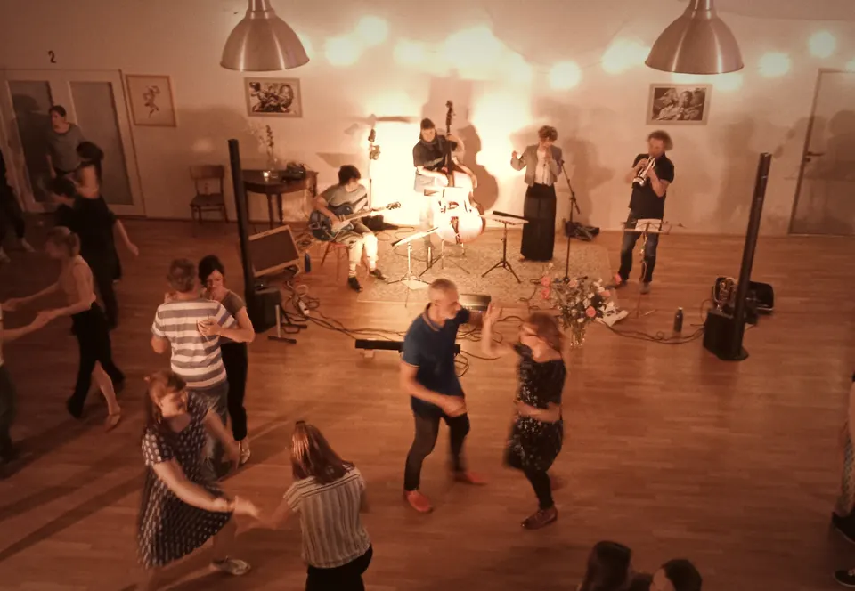 Social mit Live-Band im roten Licht, von oben gesehen, Paare tanzen davor